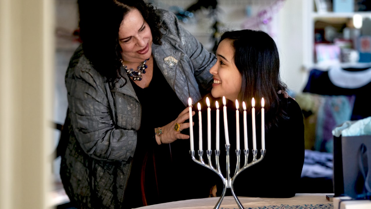 Two women next to menorah
