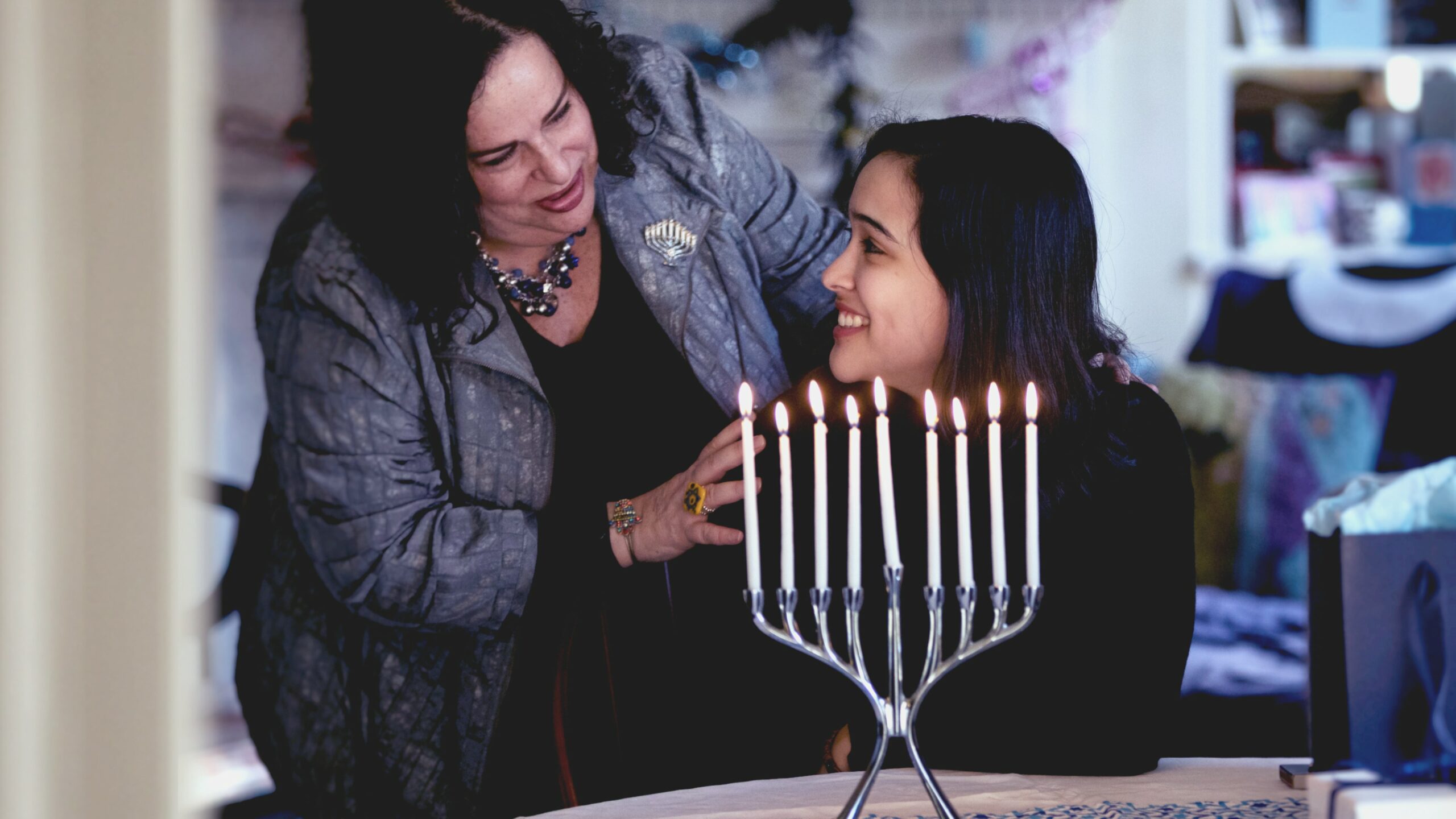 Two women by menorah.